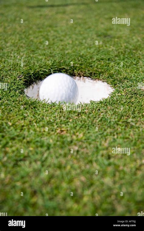 Golf Ball Falling Into Hole Stock Photo Alamy
