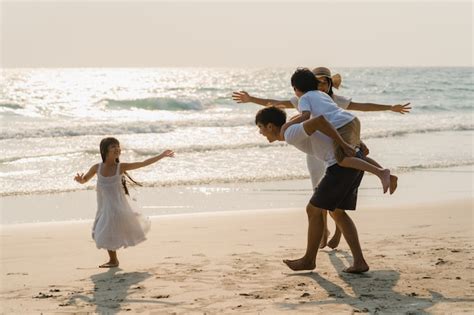 La Familia Feliz Joven Asiática Disfruta De Vacaciones En La Playa En