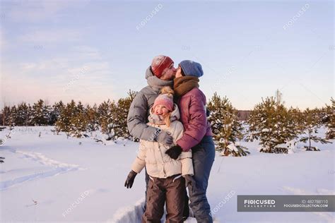 Besos Padres Abrazando Linda Hija En La Nieve Durante El Invierno