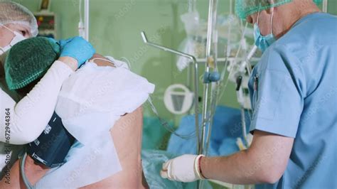 Male Doctor Injecting Epidural Anesthesia For Pregnancy Labor During