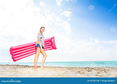 Adolescente Che Sta Con I Matrass Sulla Spiaggia Sabbiosa Fotografia