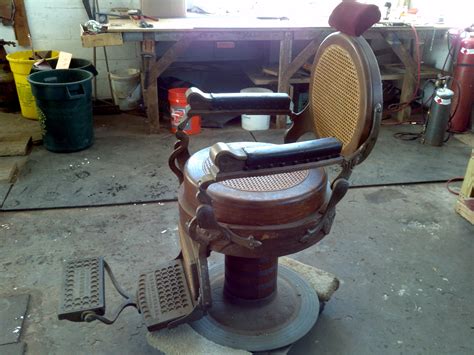 Young man in the barber shop at the master. Antique 1901Berninghaus Wooden Barber Shop Chair ...