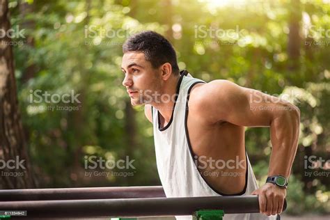 Well Built Muscular Man Doing A Physical Exercise Outdoors Stock Photo