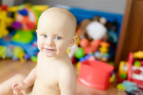 Bebé Desnudo Que Se Sienta Que Sonríe Divirtiéndose En Casa Foto de archivo Imagen de