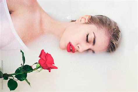 An Attractive Young Woman Lies In Milk Bath Holding A Red Rose By Jovana Rikalo Stocksy United