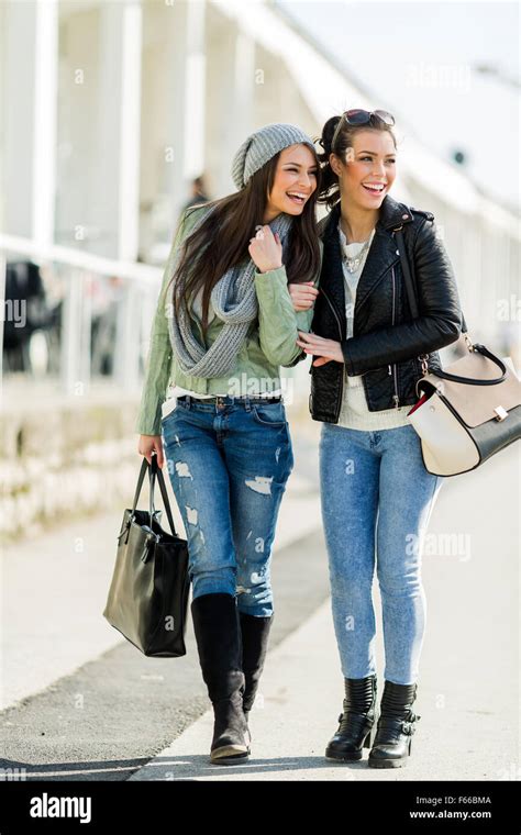 Two Young Beautiful Women Walking And Shopping With Joyful Expressions