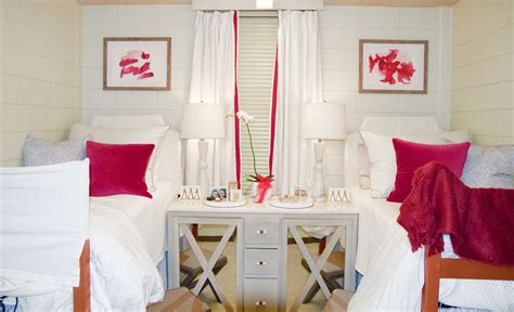 Two Beds In A Small Room With White Walls And Red Pillows On The Bedding