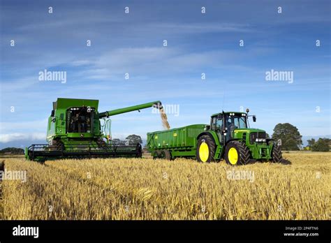 John Deere combine harvester harvesting barley (Hordeum vulgare
