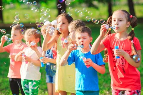 The Group Of Children Blowing Soap Bubbles Stock Photo Image Of