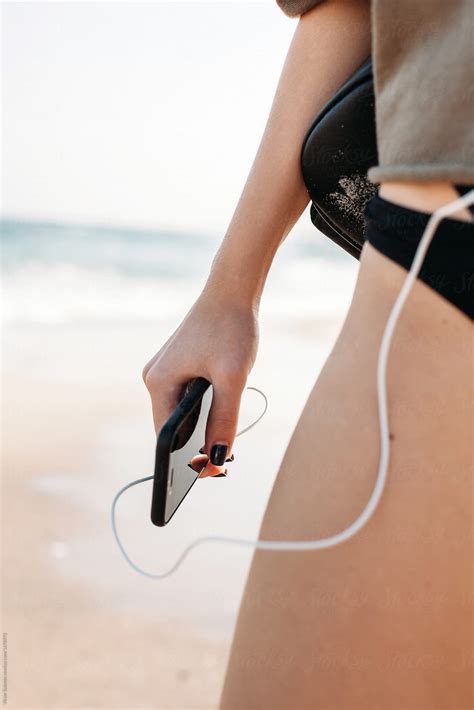 Woman Hand Beach Smartphone Earphones Music Closeup Del Colaborador De Stocksy Viktor Solomin