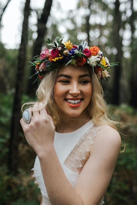 A Woman Wearing A Flower Crown Holding A Ring In Her Hand And Smiling
