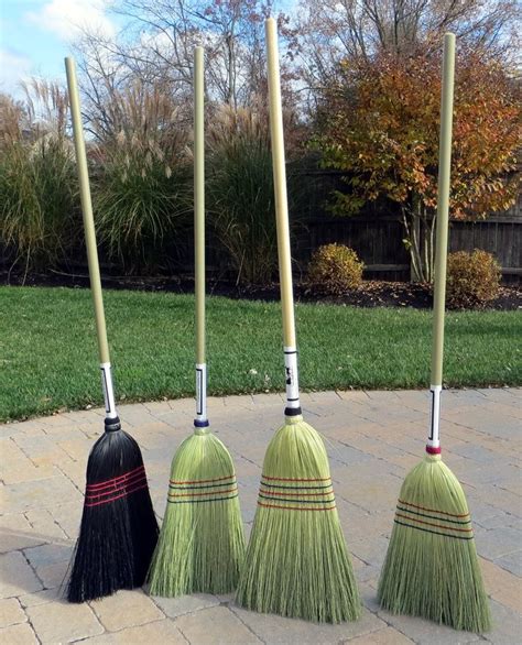 Four Brooms Are Lined Up In A Circle On The Sidewalk One Is Black And