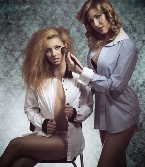 Dos chicas jóvenes posando junto con el maquillaje y peinados fotografía de stock Vitalii