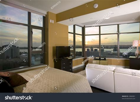 Interior Of A High Rise Condo At Sunset With A Bed And Couch In The