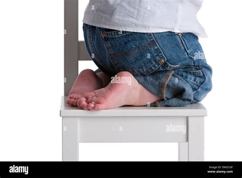 Childs Feet On A Small Chair On White Background Stock Photo Alamy