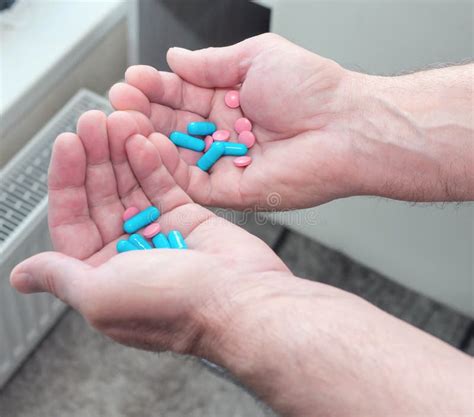 an elderly man has pills in his hands the concept of treatment with pills prescribed by a