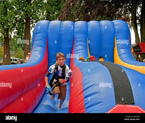 This Boy Is Running On An Inflated Toy Ramp Playing A Game During The