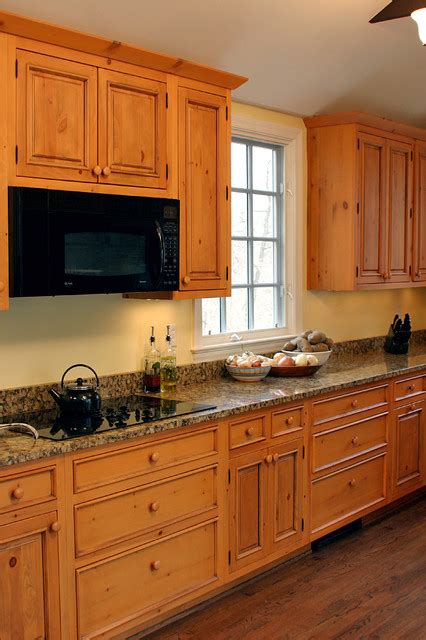 Matching a knotty pine cabinetry run with formica countertops and wrought iron hardware was a very popular décor. Knotty pine cabinets, granite counter-top - Traditional ...