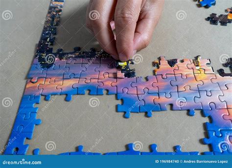 Woman S Hands Placing A Puzzle Piece In Its Place Stock Photo Image