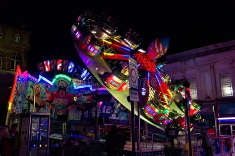 a spinning fairground ride at night with motion blur editorial photography image of smoke