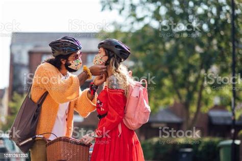 Man Helping His Girlfriend With Her Helmet Stock Photo Download Image