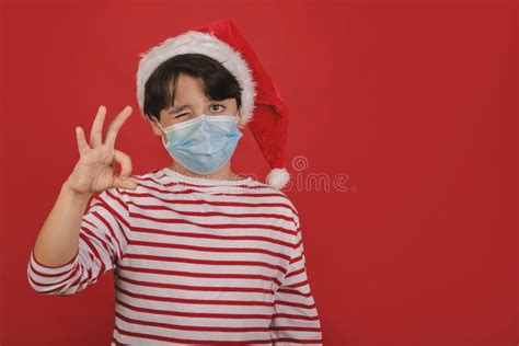 Merry Christmaskid With Medical Mask Wearing Santa Claus Hat Showing