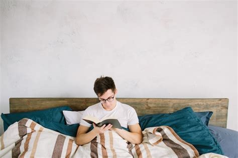 Premium Photo Man Reading A Book On His Bed At Home