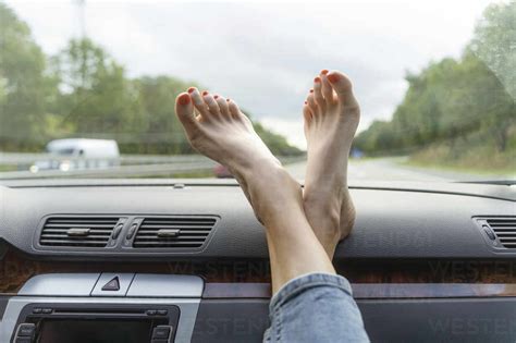 Mature Woman With Feet Up On Car Dashboard Stock Photo