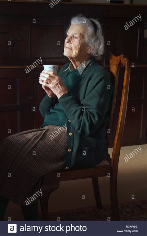 Portrait Of Old Lady Sitting On High Backed Mahogany Chair She Holds A
