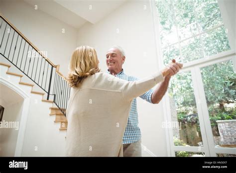 Senior Couple Dancing Together In Living Room At Home Stock Photo Alamy