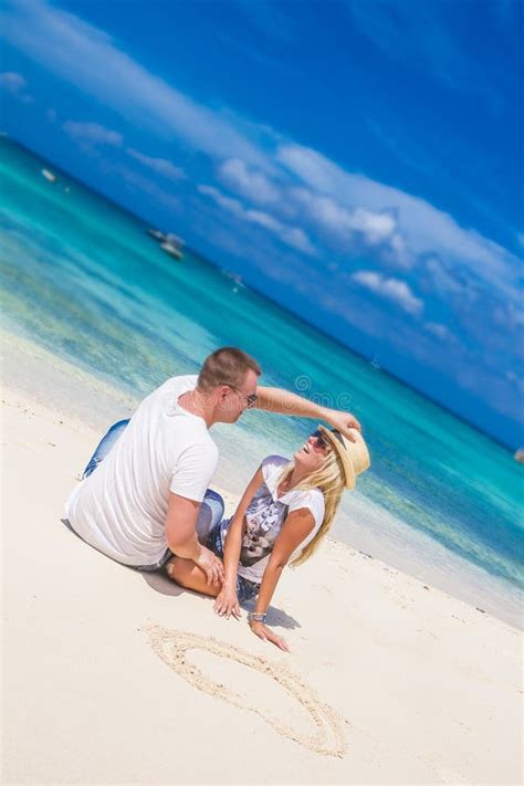 Young Loving Couple Relaxing On Sand Tropical Beach On Blue Sky Stock