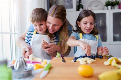 Cute Kids With Mother Preparing A Healthy Fruit Snack In Kitchen Stock