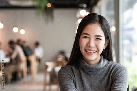 Portrait Of Young Attractive Asian Woman Looking At Camera Smiling With Confident And Positive