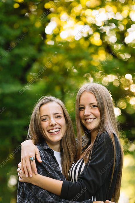 Portrait Of Two Young Female Friends Hugging In Park