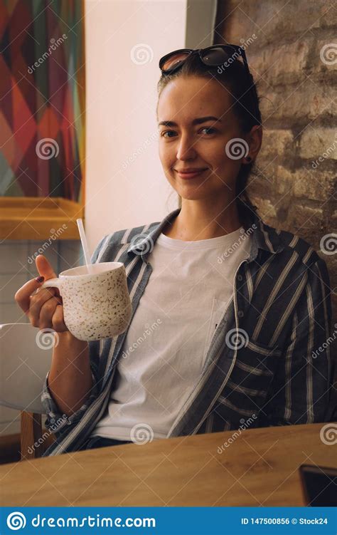 Young Pretty Woman Sitting In A Cafe And Talking On The Phone The Girl