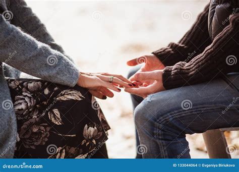 Cropped Shot Of Young Couple In Love Holding Hands While Sitting