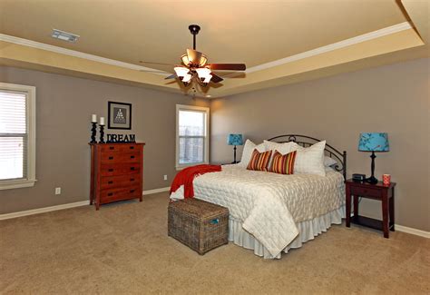 Large Master Bedroom With Tray Ceilings Crown Molding A Large Ceiling Fan And Neutral Colors
