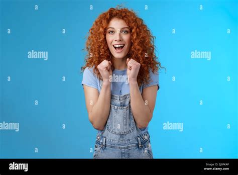 Cheerful Optimistic Lucky Redhead Curly Haired Attractive Woman Cheering Clench Fists Joyfully
