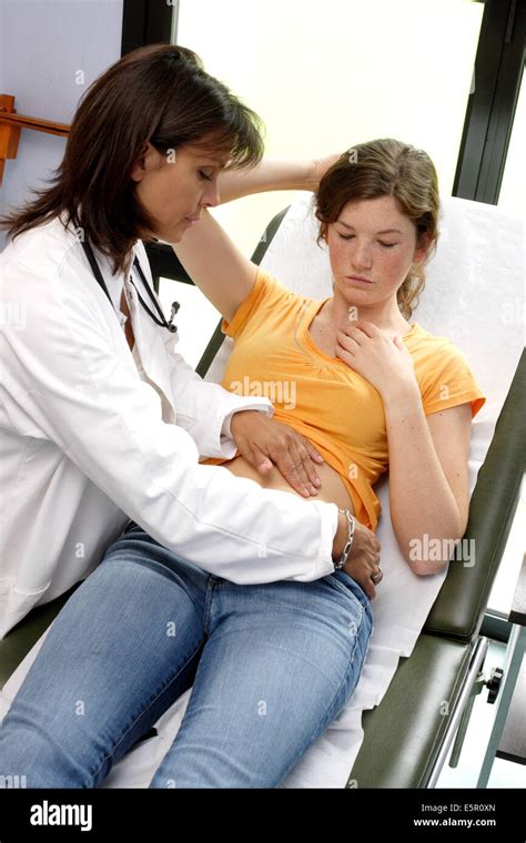 Doctor Examining The Abdomen Of A Female Teenager By Palpation Stock