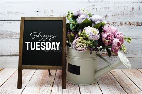 Happy Tuesday Text On Blackboard Easel With Flower Bouquet On Wooden
