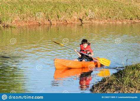 8 Year Old Brazilian Child Sailing In A Kayak In A Small River On A
