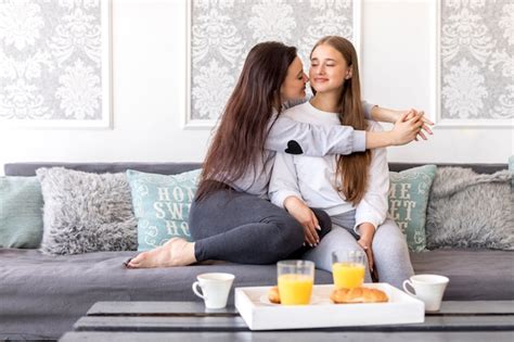 free photo tender lesbian couple sitting on sofa with breakfast