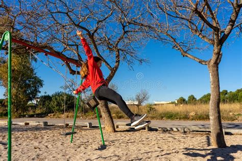 Teenage Girl Jumping Off A Swing Set Flies Through The Air Just Like