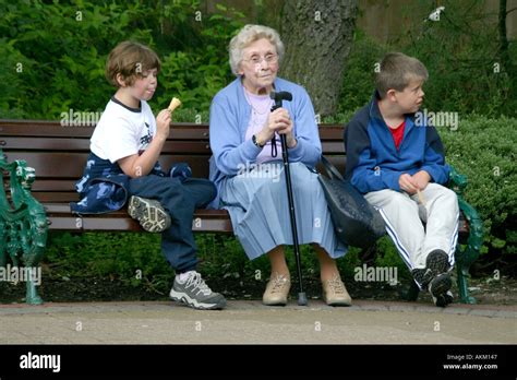 Old Lady With Two Young Boys Sat On Bench Stock Photo Alamy