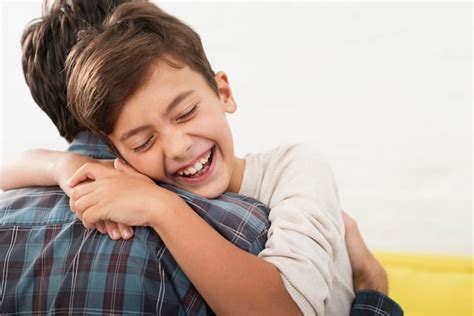 Feliz Niño Abrazando A Su Padre Foto Gratis