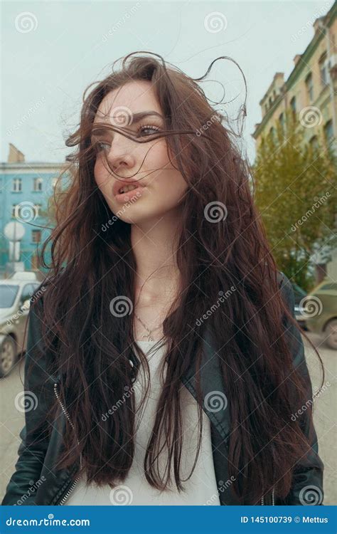 Brooding Woman With Windy Hai Posing Outside Street Fashion Stock
