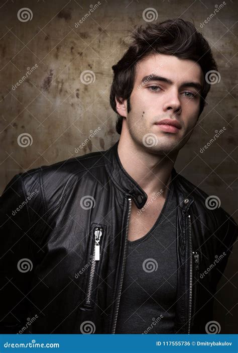 Young Man In Black Leather Jacket Posing By Metal Walls Portrait Of