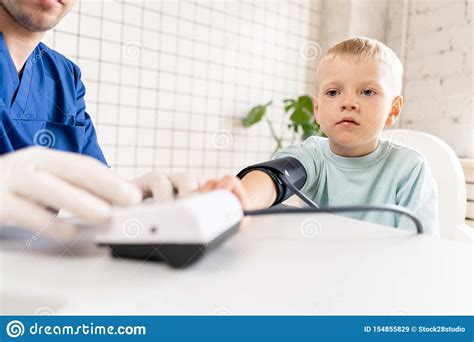 Little Boy Visiting Doctor In Hospital Measuring Blood Pressure And