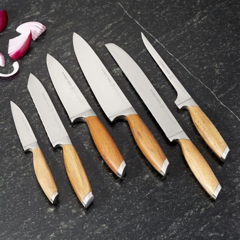 Five Knives With Wooden Handles Are Lined Up On A Table