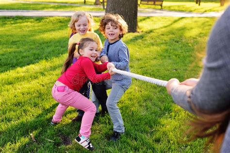 Children Play Tug Of War In The Park Stock Photo Image Of Color